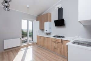 Moderne Einbauküche mit Holzfronten, Gaskochfeld und schwarzer Dunstabzugshaube